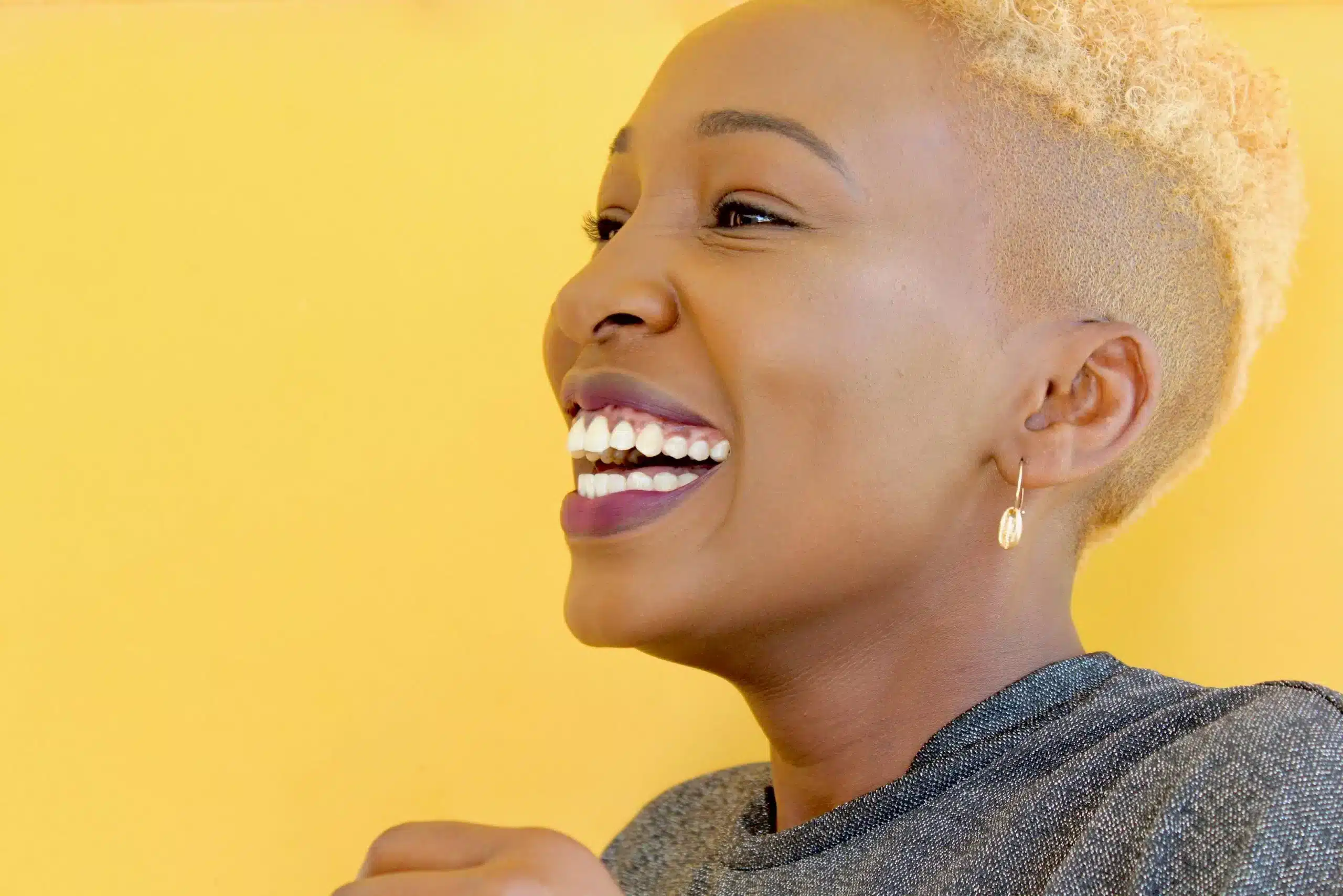 A smiling woman with straight white teeth with dental implants