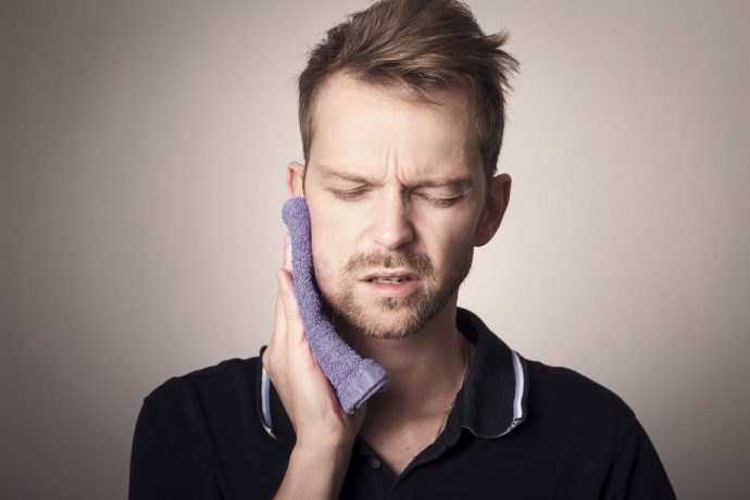 a man experiencing jaw pain from TMJ